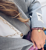 Influencer draagt roze bedelarmband