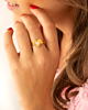 Model draagt gouden ring met roze hartje