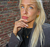 Influencer met gouden oorbellen, ring en initial ketting