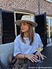 Influencer met gouden kettingen, hoops en hoed