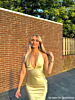 Influencer met gele jurk en gouden kettingen