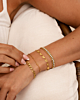 Model draagt gouden armbanden mix