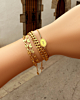 Gouden bedelarmbanden om pols