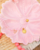 roze touw ketting met gouden bedeltjes op roze bloemen schaaltje