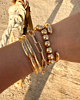 gouden combinatie van armbanden op het strand