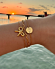 gouden armbanden combinatie bij zonsondergang