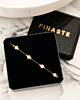 gouden armband met pastel steentjes in sieradendoosje