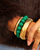 Gouden armparty met bangles en groene kralen