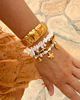 Gouden armparty met witte steentjes