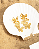 gouden statement oorbellen op het strand op witte schelp