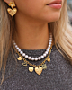 Model draagt necklaceparty met parels en hartjes