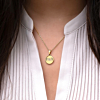 Gouden ketting met letter bij een roze top