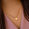 Graveerbare ketting om de hals van een vrouw met donker haar