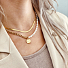 Blonde vrouw met necklace layer met parels en gravering goud