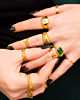mix van gouden ringen met gravering en groene details om vingers