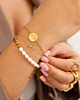 Model draagt gouden armparty om pols