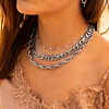 Model draagt necklace layer met zilveren kettingen