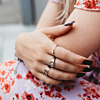 Model draagt mix van zilveren ringen om hand