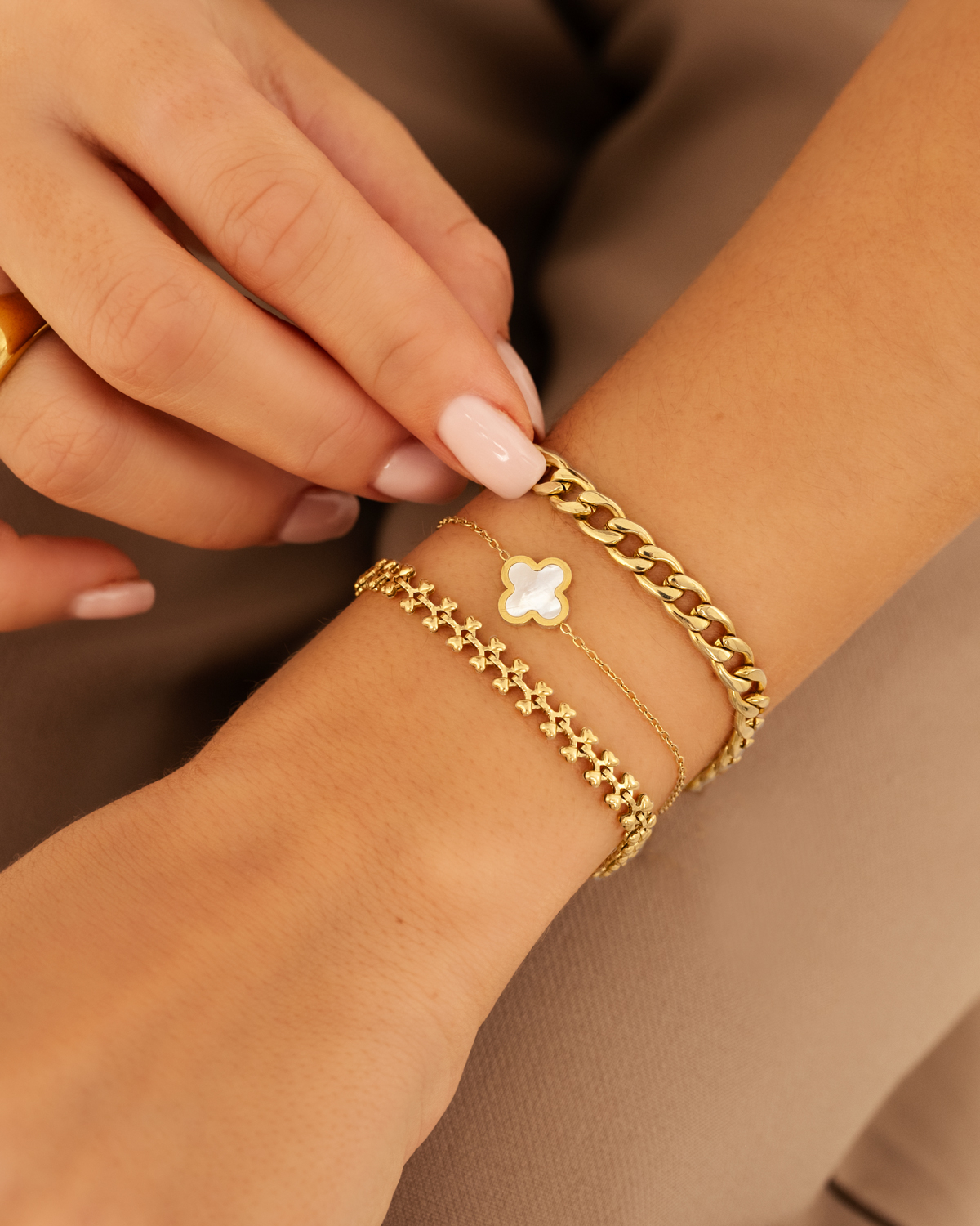 model draagt gouden armbanden