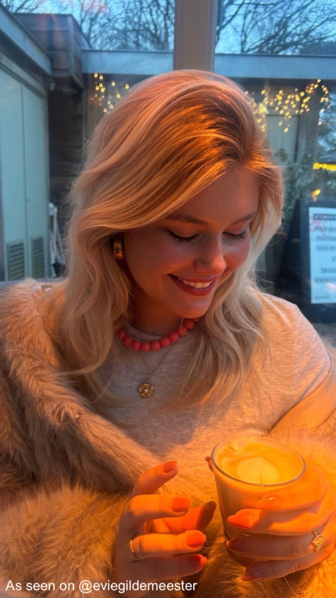 Influencer draagt roze kralenketting