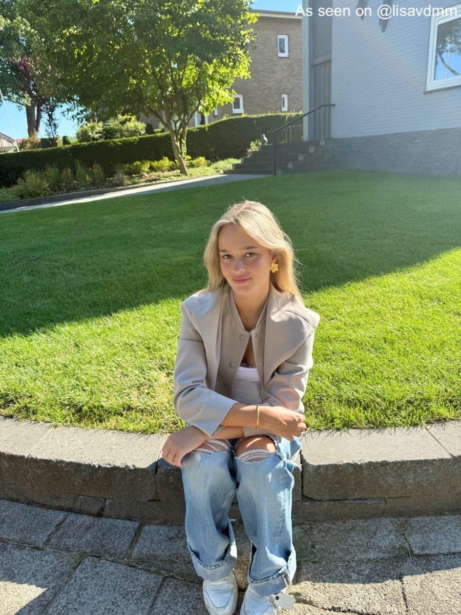 Influencer draagt gouden stud oorbel met bloem