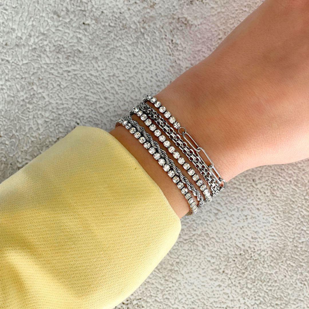 Trendy armbanden in het zilverkleurig om de pols van het model