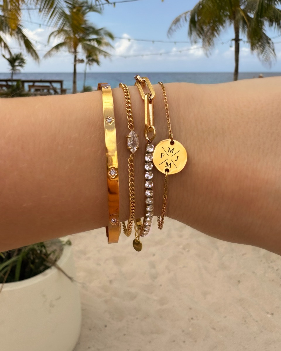 Gouden armparty met steentjes op het strand