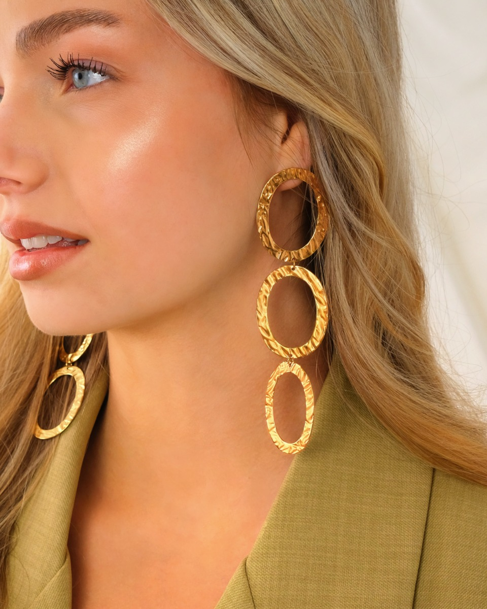 Gouden ovale oorhangers bij model