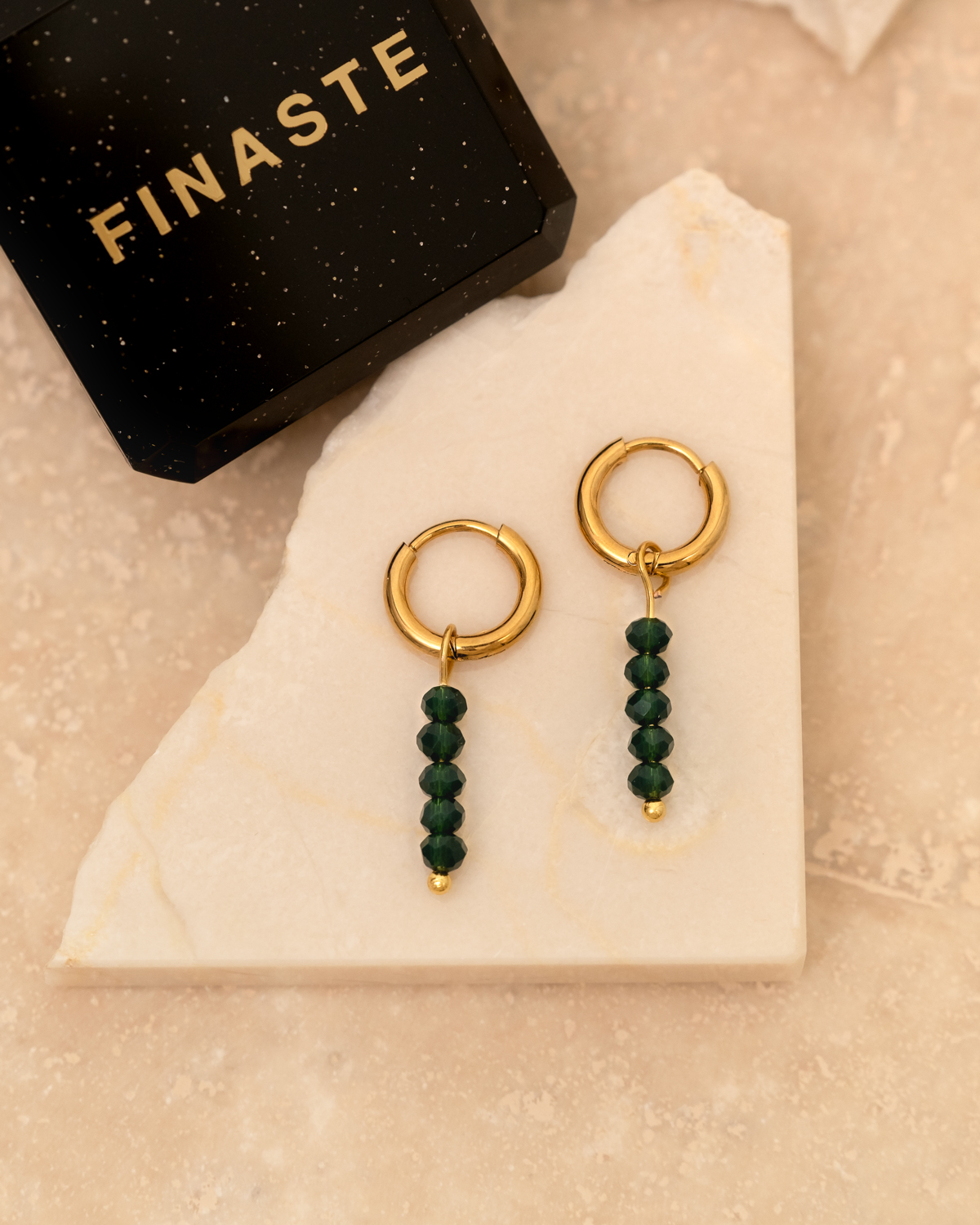 Gouden oorringetjes met groene steentjes