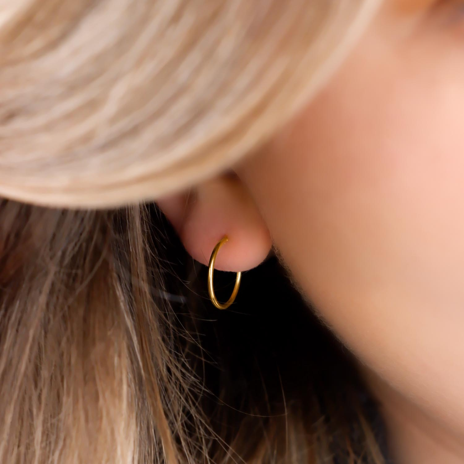 Trendy oorringetjes in het oor voor een complete look