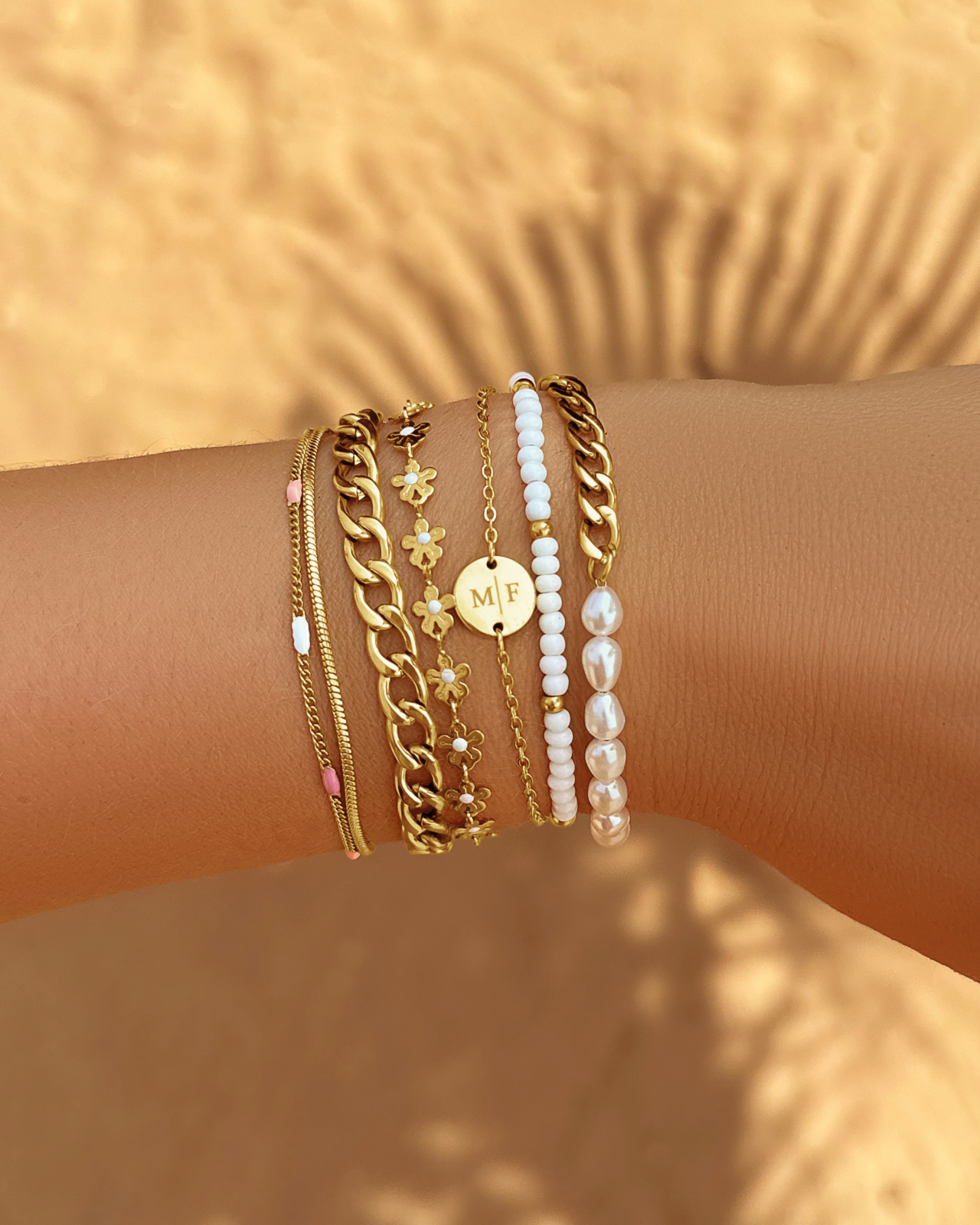 Gouden parelarmband in armparty