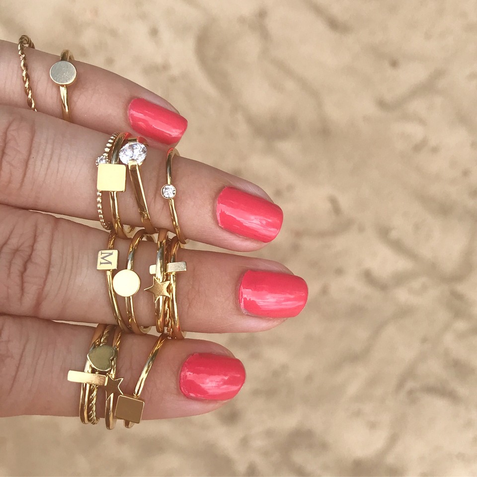 Gouden ringen om vingers op het strand