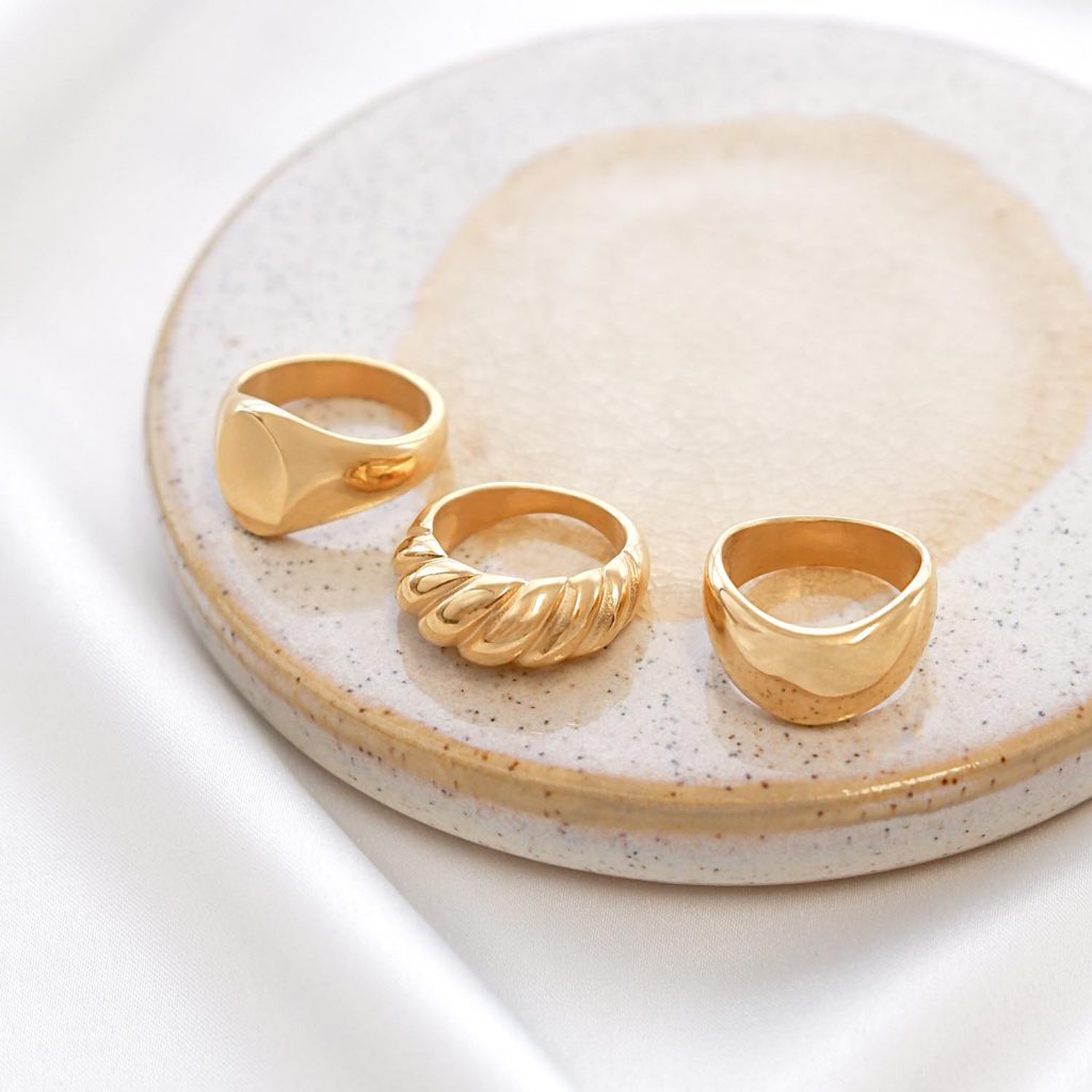 gouden chunky rings op marmer