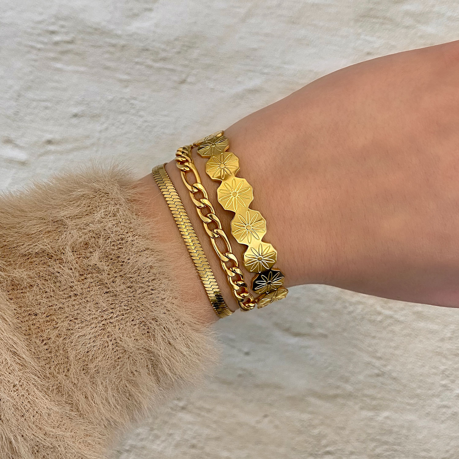 gouden armparty met bangle om pols