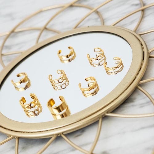 gouden ear cuffs op spiegel