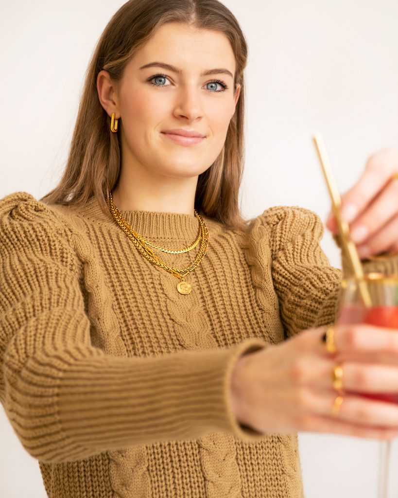 vrouw met sieraden en cocktail