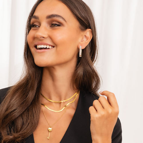 model draagt gouden necklace layer