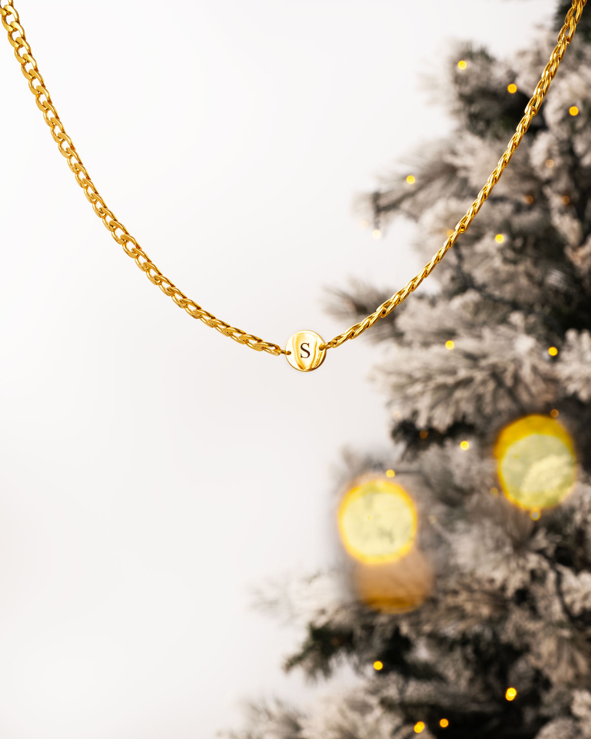 gouden schakelketting met initials bij kerstboom