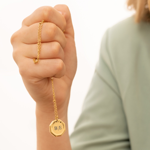 Meisje heeft gouden graveerbare ketting in haar hand