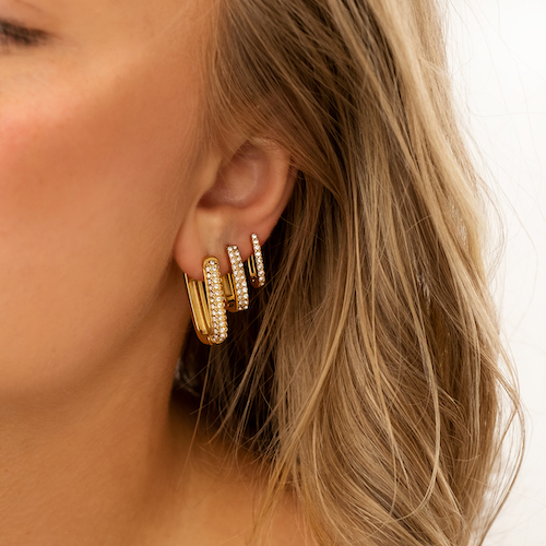 3 gouden shiny hoops in oor van blond meisje